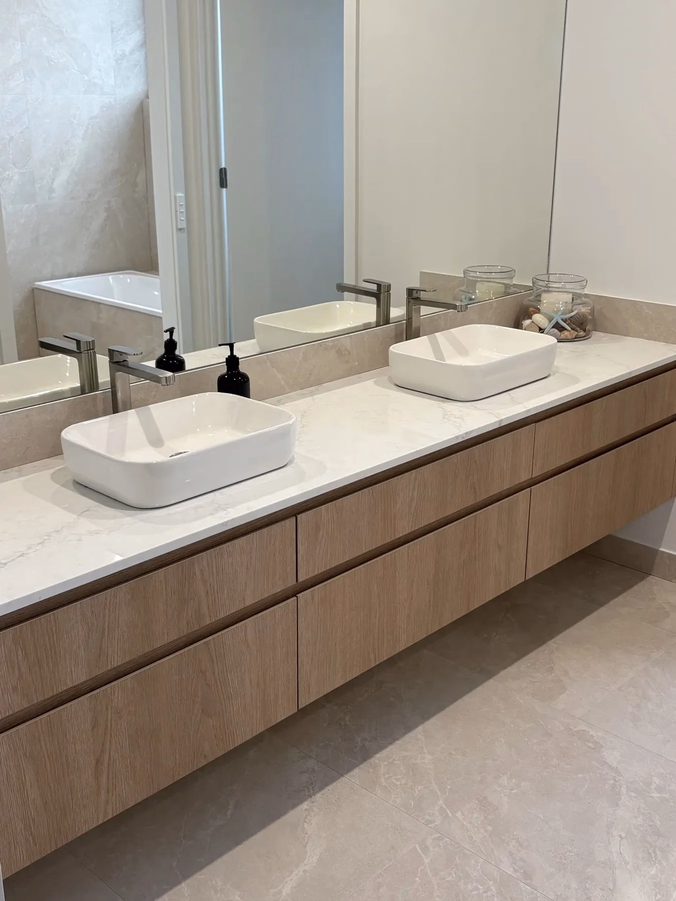 Finished bathroom with twin basins and wall-mounted tapware