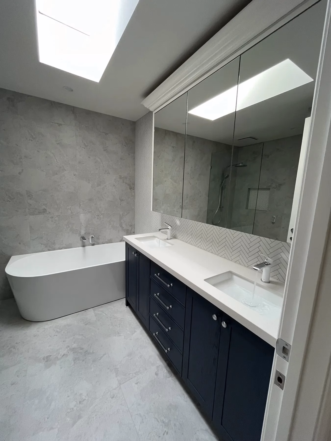 Freestanding bath, vanity basins and chrome tapware in a finished bathroom